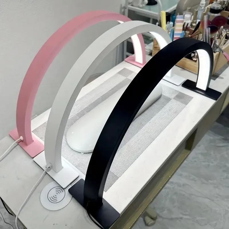 White, pink and black half moon lamps lined up in three colors